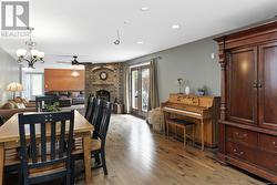 Dining space featuring ceiling fan with notable chandelier, a fireplace, and light hardwood / wood-style flooring - 