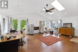 Office area featuring a wealth of natural light, a skylight, dark hardwood / wood-style floors, and ceiling fan - 