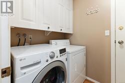 Clothes washing area with washing machine and clothes dryer and cabinets - 