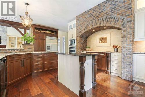 At the heart of the home the spacious chef’s kitchen offers an island breakfast bar, granite counters, built-in appliances, plenty of high-end cabinetry & counter space.  Custom backsplash & pantr - 165 Adrien Street, Clarence-Rockland, ON - Indoor Photo Showing Kitchen