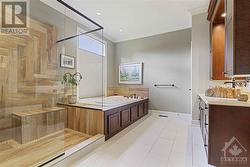 Spa-like ensuite for the primary bedroom is a dream and boasts a 2 person jet tub, custom shower, unique stone sink, and quartz counters. - 