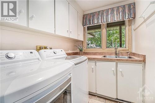 Convenient main floor laundry room with great storage and updated machines - 7 Lockview Road, Ottawa, ON - Indoor Photo Showing Laundry Room