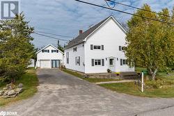 View of front facade featuring an outdoor structure and a garage - 