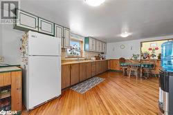 Kitchen with sink, light hardwood / wood-style flooring, decorative backsplash, white fridge, and beverage cooler - 