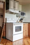 Kitchen featuring light hardwood / wood-style flooring and white appliances - 