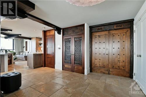 Exotic and unique detailing on the double entry doors accented with warm Limestone floor tiles - 40 Boteler Street Unit#1102, Ottawa, ON - Indoor Photo Showing Other Room