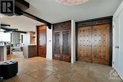 Exotic and unique detailing on the double entry doors accented with warm Limestone floor tiles - 