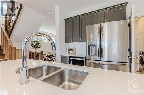 Center island with white & sleek quartz counter and breakfast bar - 600 Triangle Street, Ottawa, ON - Indoor Photo Showing Kitchen With Double Sink