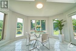 Bright eating area with windows, skylights and serene garden views. - 