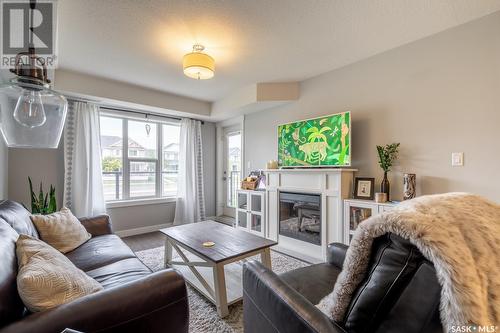 117 5301 Universal Crescent, Regina, SK - Indoor Photo Showing Living Room With Fireplace