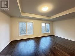 Spare room featuring dark hardwood / wood-style flooring and a tray ceiling - 