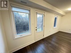 Doorway to outside featuring dark hardwood / wood-style flooring and a healthy amount of sunlight - 