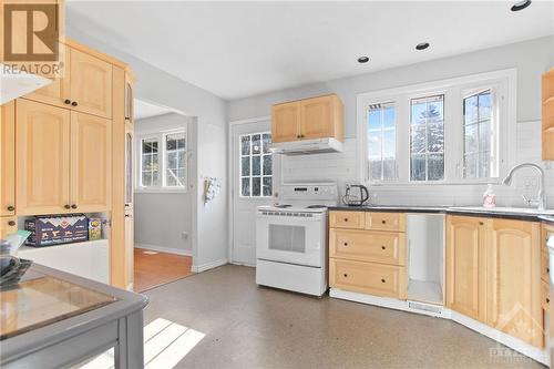 Window overlooking backyard with access door - 14 Langholm Crescent, Ottawa, ON - Indoor Photo Showing Kitchen