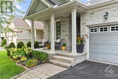 Elegant front porch, framed by classic pillars and lush landscaping, providing a welcoming entrance to this modern home. - 316 Eckerson Avenue, Ottawa, ON - Outdoor With Deck Patio Veranda With Facade