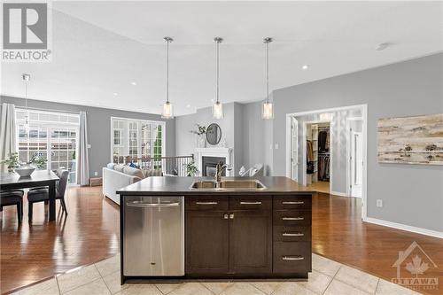 Spacious open-plan living and dining area with elegant lighting, hardwood floors, and a cozy seating area, ideal for family gatherings - 316 Eckerson Avenue, Ottawa, ON - Indoor Photo Showing Kitchen With Double Sink