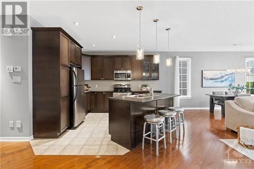 Contemporary kitchen featuring dark wood cabinetry, stainless steel appliances, and a spacious island that is perfect for entertaining. - 316 Eckerson Avenue, Ottawa, ON - Indoor Photo Showing Kitchen With Upgraded Kitchen