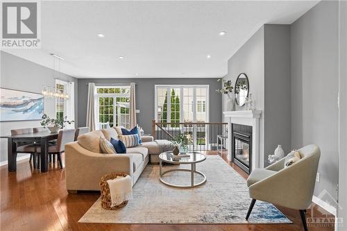 Spacious living area with large windows, a contemporary fireplace, hardwood floors, a bright and inviting space for relaxation and entertainment - 316 Eckerson Avenue, Ottawa, ON - Indoor Photo Showing Living Room With Fireplace