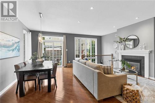 Modern living room with a cozy fireplace, and open layout that connects seamlessly to the kitchen and dining areas, perfect for comfortable family living. - 316 Eckerson Avenue, Ottawa, ON - Indoor Photo Showing Living Room With Fireplace