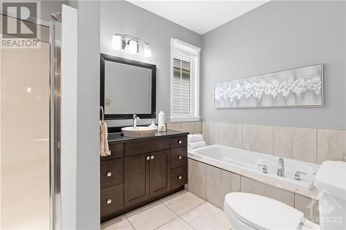 Luxurious bathroom featuring a deep soaking tub, modern vanity, and separate glass-enclosed shower, ideal for unwinding after a long day. - 316 Eckerson Avenue, Ottawa, ON - Indoor Photo Showing Bathroom