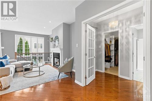 Family room with Gas fireplace leading through the french doors to the primary bedroom with walk-in closet, and gorgeous ensuite. - 316 Eckerson Avenue, Ottawa, ON - Indoor Photo Showing Living Room