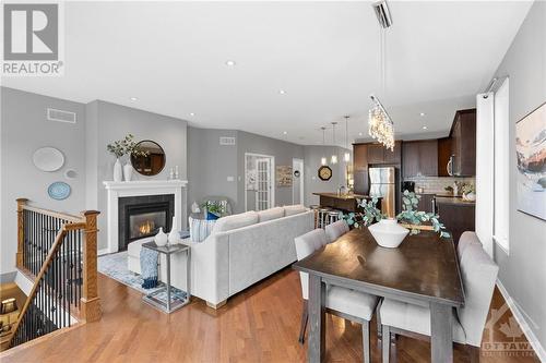 Open-concept living and dining area with hardwood floors, modern fireplace, and abundant natural light, perfect for entertaining and family gatherings. - 316 Eckerson Avenue, Ottawa, ON - Indoor With Fireplace