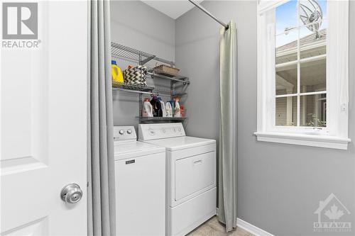 Functional laundry room with a washer and dryer, built-in shelving for organization, and a window for natural light. - 316 Eckerson Avenue, Ottawa, ON - Indoor Photo Showing Laundry Room