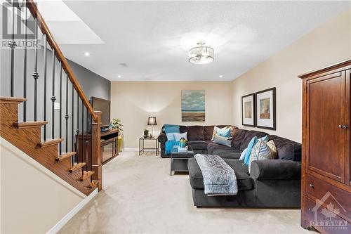 Spacious family room featuring with soft carpeting, and a sleek staircase, ideal for hosting gatherings or movie nights. - 316 Eckerson Avenue, Ottawa, ON - Indoor