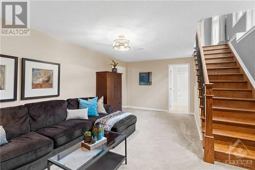 Great family rec room with carpeting and natural light. Perfect for hanging out as a family and for those fun movie nights. Gorgeous new hardwood stairs - 316 Eckerson Avenue, Ottawa, ON - Indoor Photo Showing Living Room