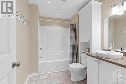 Modern bathroom with a clean design featuring a vessel sink, bathtub, and stylish white cabinetry, providing a fresh and welcoming feel - 316 Eckerson Avenue, Ottawa, ON - Indoor Photo Showing Bathroom