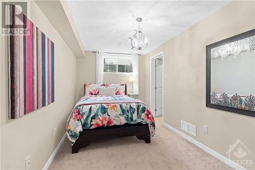 Charming bedroom with a playful chandelier, carpeting and neutral colours, perfect for adding personality and comfort to any living space. - 316 Eckerson Avenue, Ottawa, ON - Indoor Photo Showing Bedroom