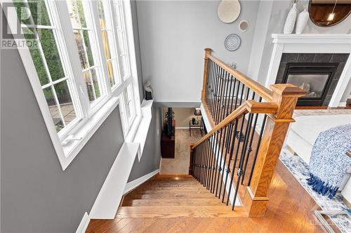 Elegant new hardwood staircase with wooden steps and wrought iron spindles, providing a stylish transition from the main living area to the lower level. - 316 Eckerson Avenue, Ottawa, ON - Indoor Photo Showing Other Room