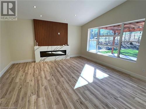 Unfurnished living room featuring light wood-type flooring and vaulted ceiling - 40 Masson Lane, Callander, ON - Indoor