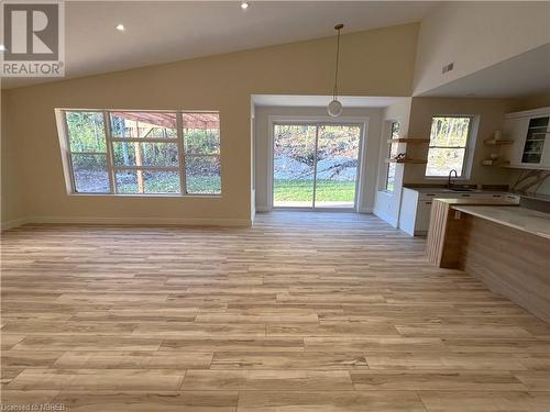 Kitchen with pendant lighting, light hardwood / wood-style floors, sink, and vaulted ceiling - 40 Masson Lane, Callander, ON - Indoor Photo Showing Other Room