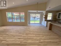 Kitchen with pendant lighting, light hardwood / wood-style floors, sink, and vaulted ceiling - 