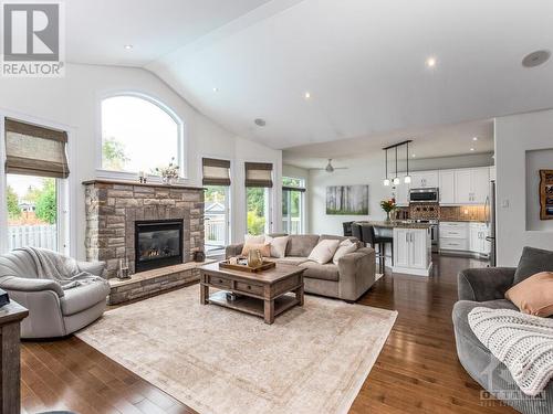 Amazing livingroom space with vaulted ceilings, beautiful stone gas fireplace, wired in speakers & lots of windows create a very warm and inviting room. A wonderful relaxing space for the whole fa - 50 Frances Colbert Avenue, Ottawa, ON - Indoor Photo Showing Living Room With Fireplace