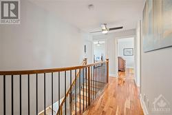 2nd floor hallway featuring ceiling fan and cherry hardwood flooring - 