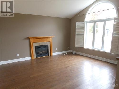 Family Room with gas fireplace, vaulted ceiling and large window with view to back yard. - 101 Shirley'S Brook Drive, Ottawa, ON - Indoor Photo Showing Living Room With Fireplace