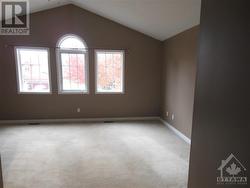 Large, bright primary bedroom with vaulted ceiling. - 