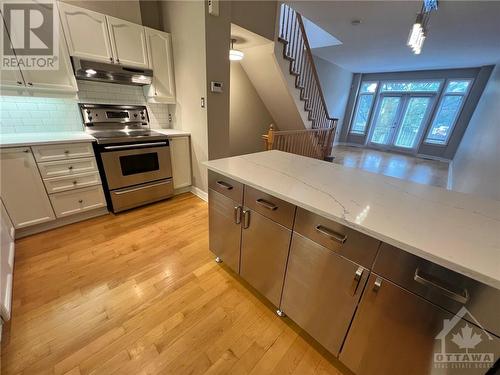 Sleek stainless steel appliances, prep island and breakfast bar - 407 Mackay Street Unit#B, Ottawa, ON - Indoor Photo Showing Kitchen