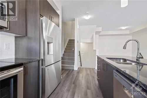 Kitchen showcases quartz counters, white subway tile backsplash, breakfast bar + an abundance of natural light. - 402 Jewelwing Private, Ottawa, ON - Indoor Photo Showing Kitchen With Double Sink With Upgraded Kitchen