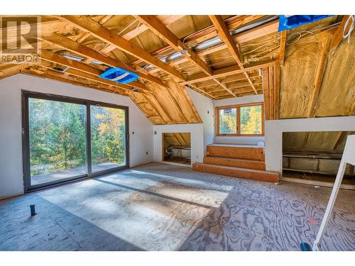 primary with balcony over looking creek / plumbing for soaker tub by window - 8726 Forsberg Road, Vernon, BC - Indoor With Fireplace