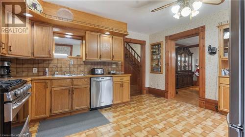 Kitchen featuring decorative backsplash, ceiling fan, sink, and stainless steel appliances - 246 Light Street, Woodstock, ON - Indoor Photo Showing Kitchen