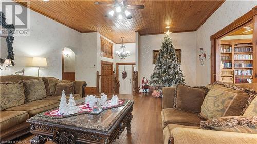 Living room with ornamental molding, wood ceiling, ceiling fan with notable chandelier, and wood-type flooring - 246 Light Street, Woodstock, ON - Indoor Photo Showing Living Room