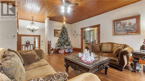 Living room with crown molding, light hardwood / wood-style flooring, wood ceiling, and ceiling fan with notable chandelier - 246 Light Street, Woodstock, ON - Indoor Photo Showing Living Room