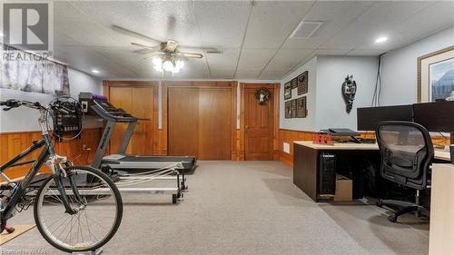 Exercise room featuring wood walls, ceiling fan, and light colored carpet - 246 Light Street, Woodstock, ON - Indoor Photo Showing Gym Room