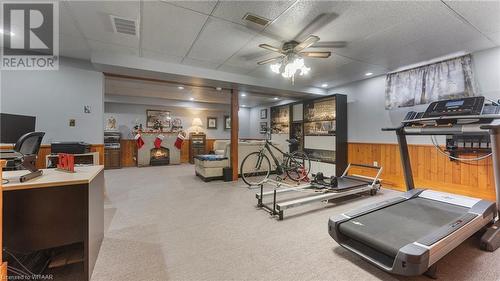 Exercise room with carpet, a drop ceiling, ceiling fan, and wood walls - 246 Light Street, Woodstock, ON - Indoor Photo Showing Gym Room