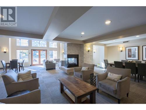 lounge located below the gym and beside the billiards room and next to the outdoor pool. - 1075 Sunset Drive Unit# 2604, Kelowna, BC - Indoor Photo Showing Living Room With Fireplace