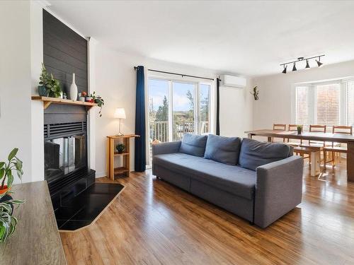 Salon - 201-20 Place Papineau, Candiac, QC - Indoor Photo Showing Living Room With Fireplace