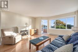 Living room with a baseboard radiator and light wood-type flooring - 