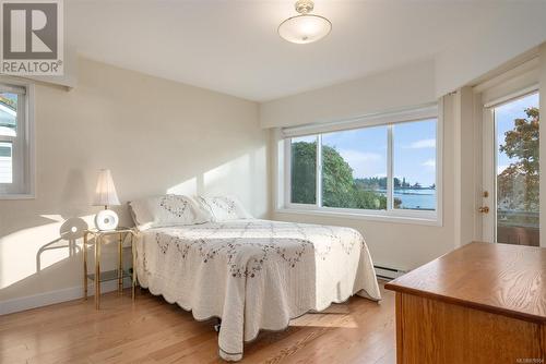 Bedroom with light hardwood / wood-style flooring, a baseboard heating unit, and a water view - 101 145 Newcastle Ave, Nanaimo, BC - Indoor Photo Showing Bedroom